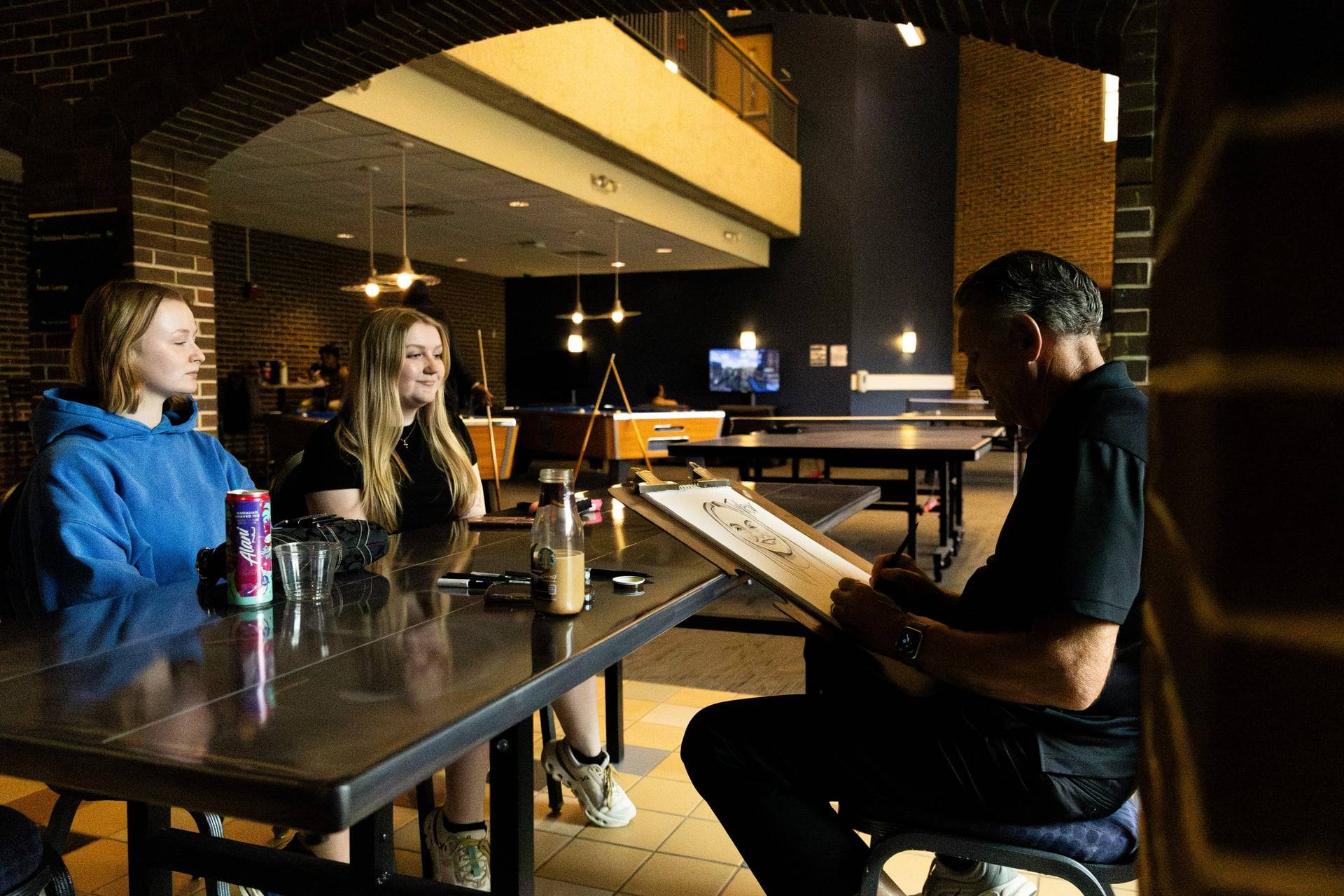 Two students at a caricutare artist